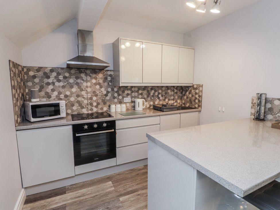 A kitchen with modern appliances including a microwave and oven at The Wren in Llysfaen