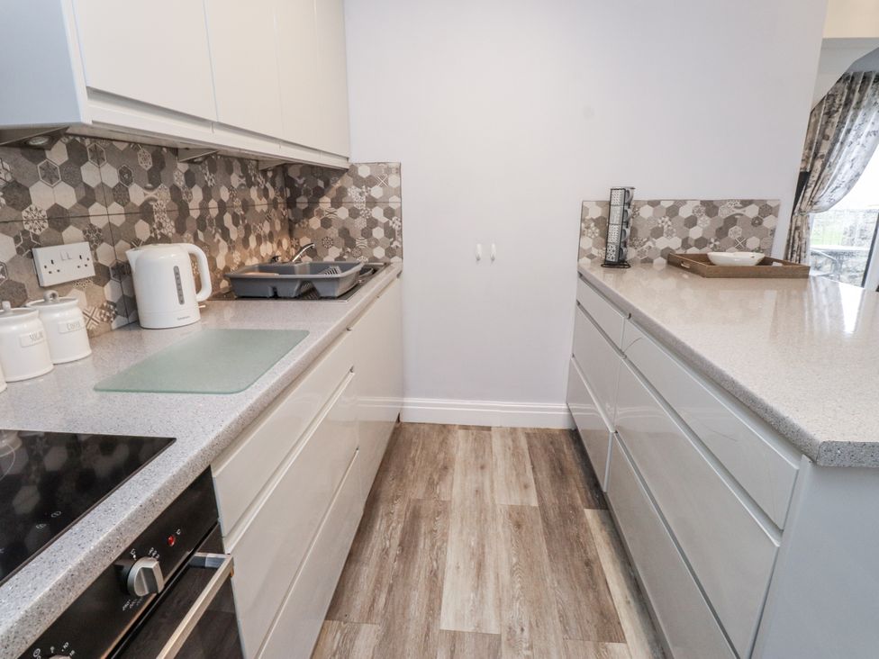 A kitchen with a kettle and storage containers at The Wren in Llysfaen