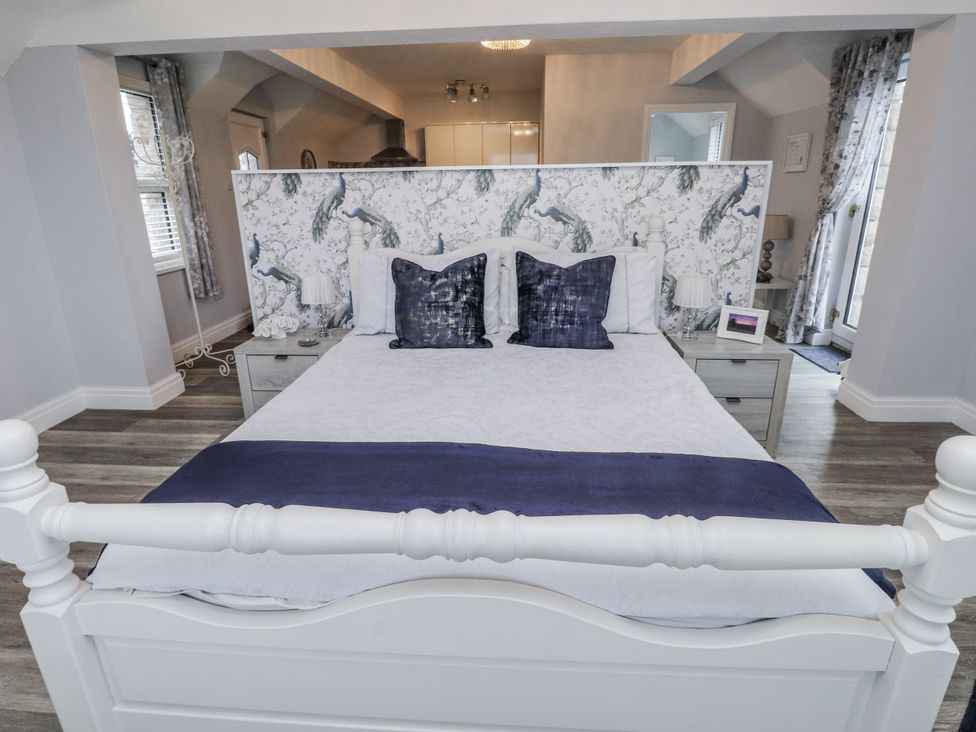 A bedroom with a double bed and side tables at The Wren in Llysfaen