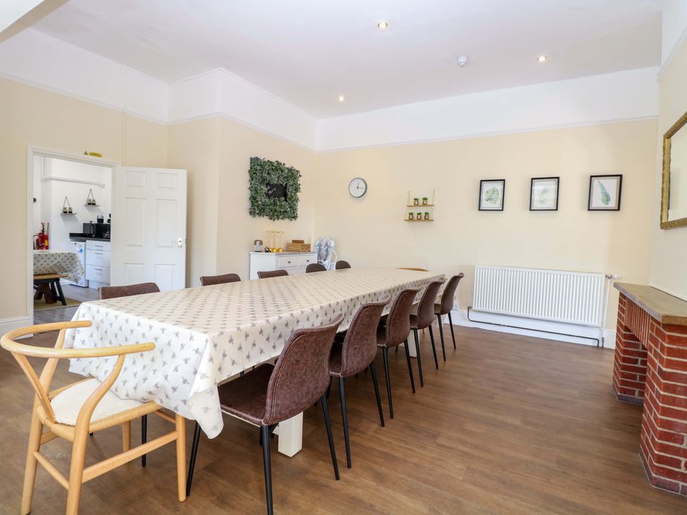 A dining room with a long table and chairs at Sunnymeade in Buxton, Norfolk