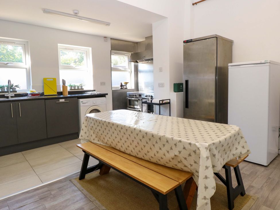 A kitchen with a table and benches at Sunnymeade, Buxton, Norfolk