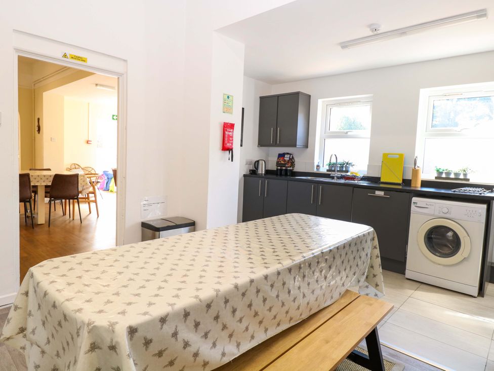 A kitchen with a table and washing machine at Sunnymeade in Buxton, Norfolk