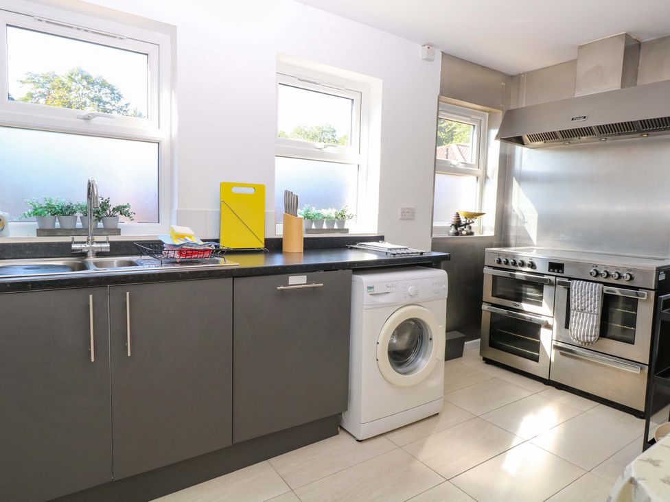 A kitchen with a sink and washing machine at Sunnymeade in Buxton Norfolk