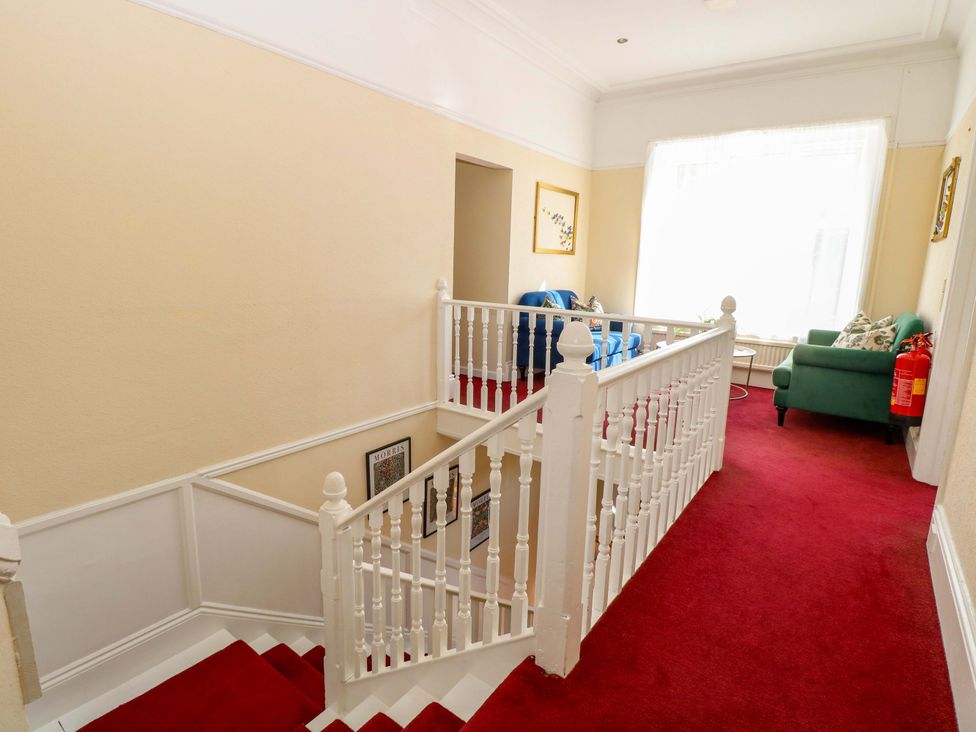 A staircase leading to a hallway with chairs at Sunnymeade in Buxton, Norfolk