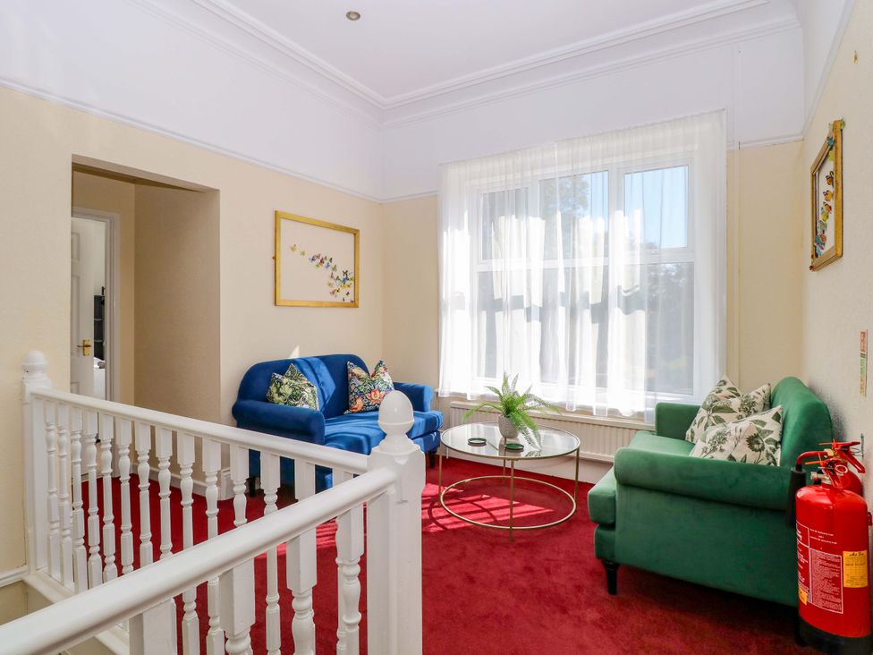 A snug room with couches and a table at Sunnymeade in Buxton, Norfolk