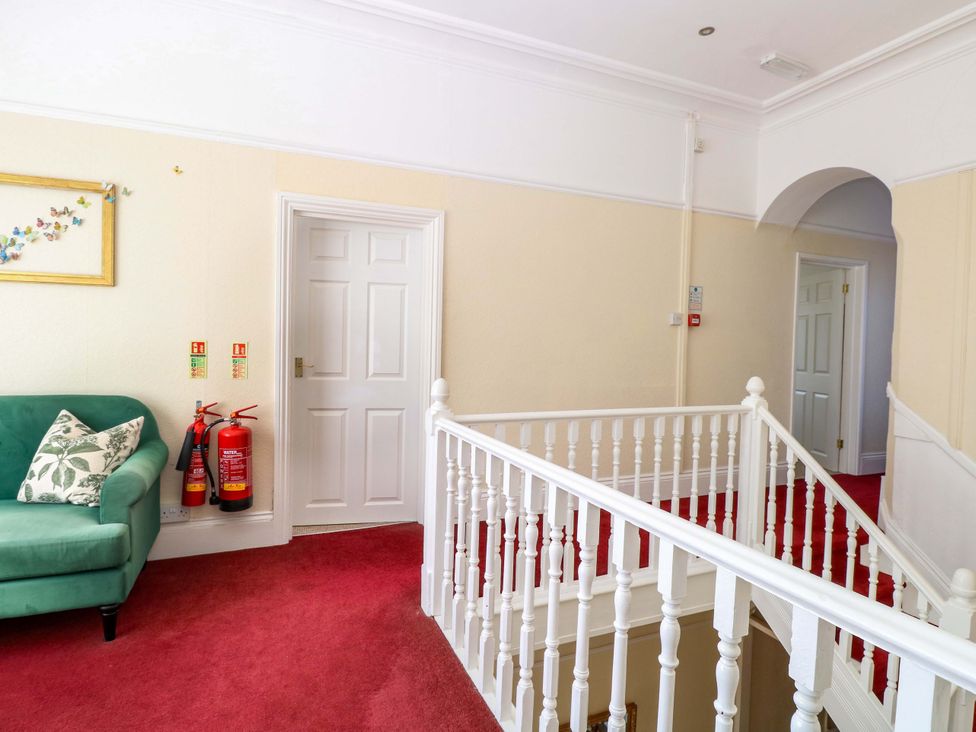 A hallway with a green sofa and a picture frame at Sunnymeade Buxton, Norfolk