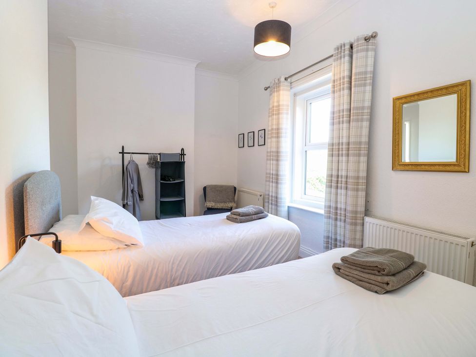 A bedroom with two beds and a mirror at Sunnymeade in Buxton, Norfolk