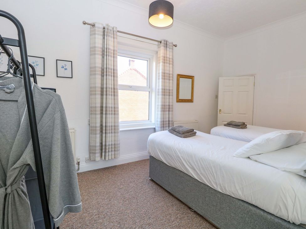 A bedroom with two beds and a window at Sunnymeade, Buxton, Norfolk