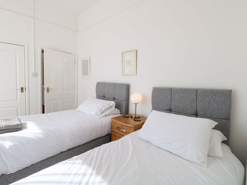 A bedroom with two beds and a nightstand at Sunnymeade, Buxton, Norfolk