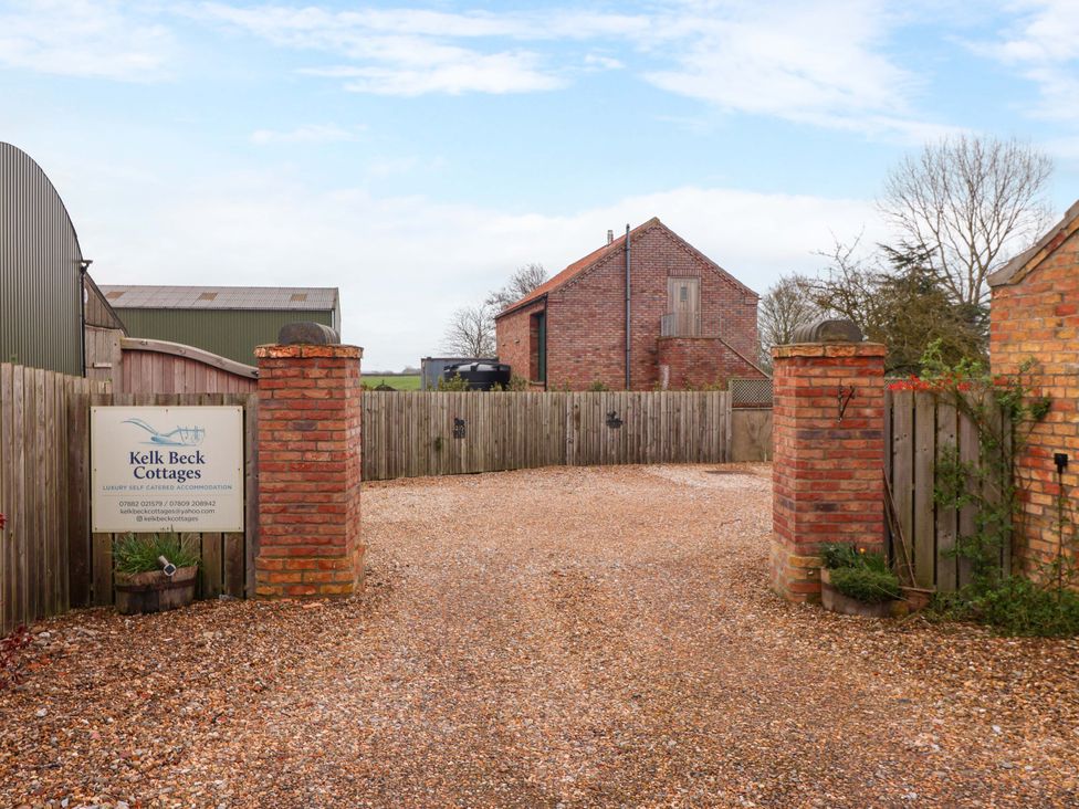 An outdoor entrance with gravel driveway and sign at Kelk Beck Cottages Little Kelk near Bridlington
