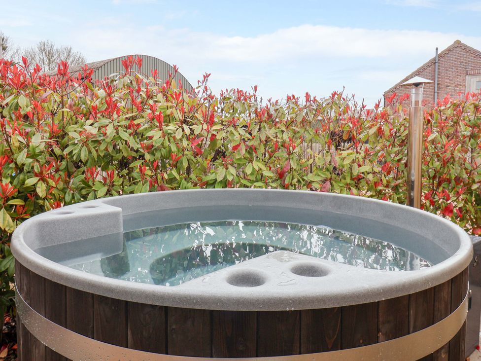 A hot tub surrounded by plants at Plough Cottage Little Kelk near Bridlington