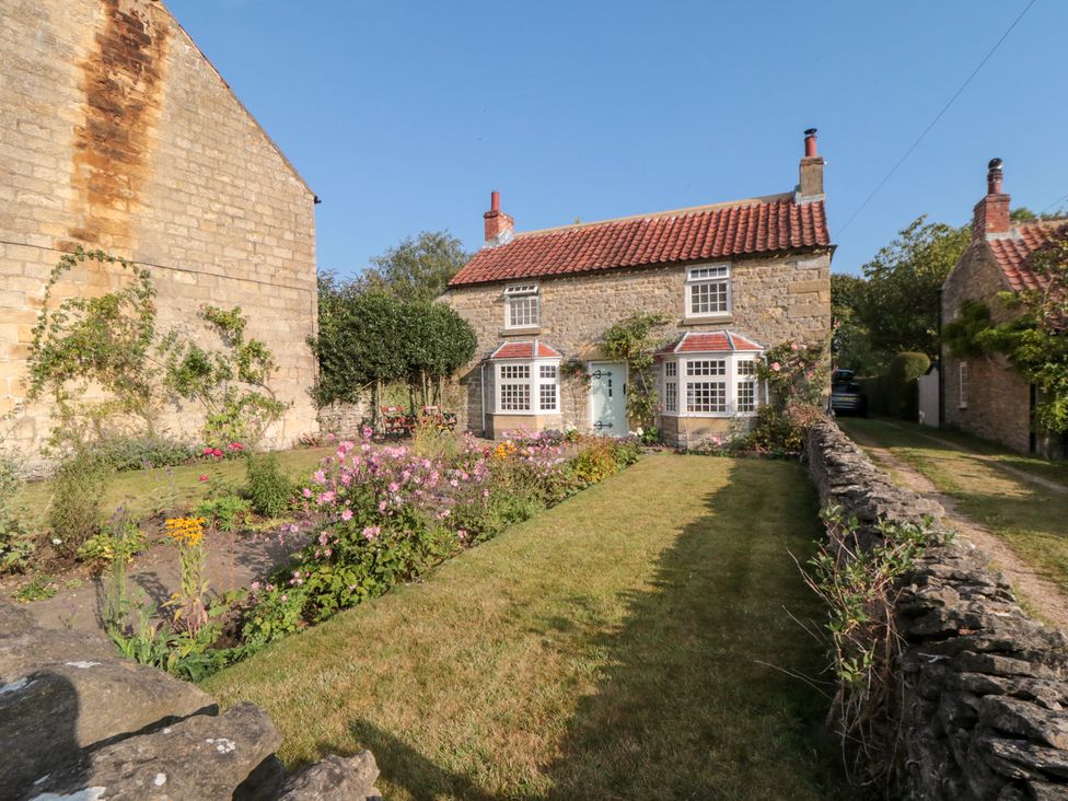 A house with a garden in front and a stone wall at Bute Cottage Lockton near Pickering
