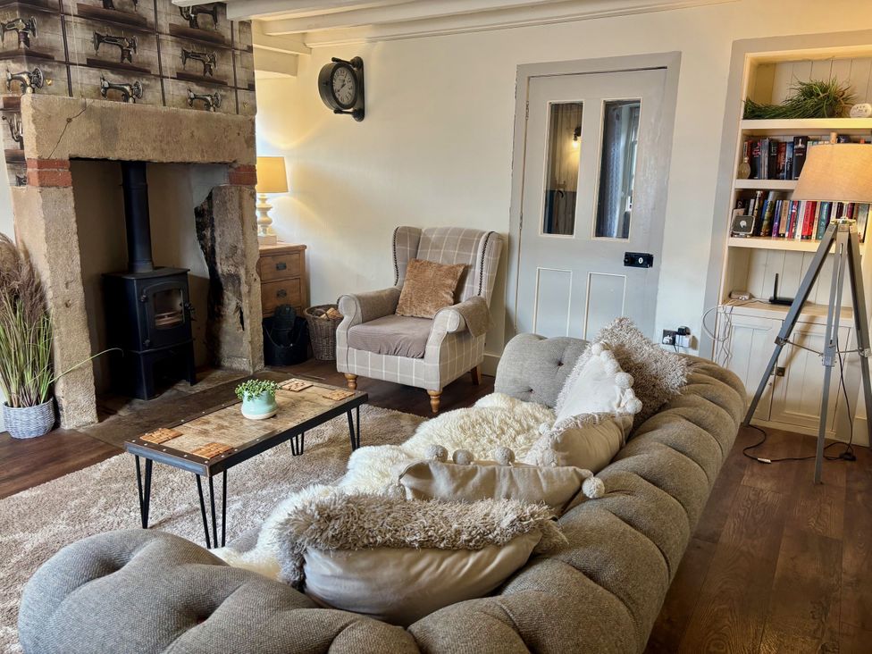 A living room with a sofa and armchair at Coupling Cottage in Belper