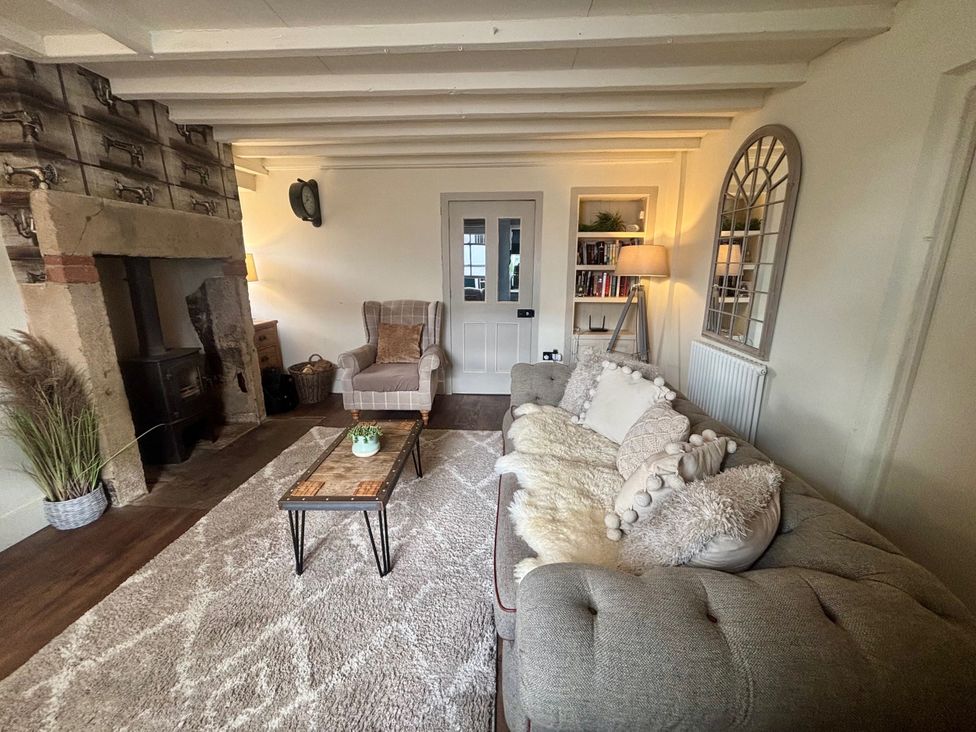 A living room with a sofa and armchair at Coupling Cottage in Belper