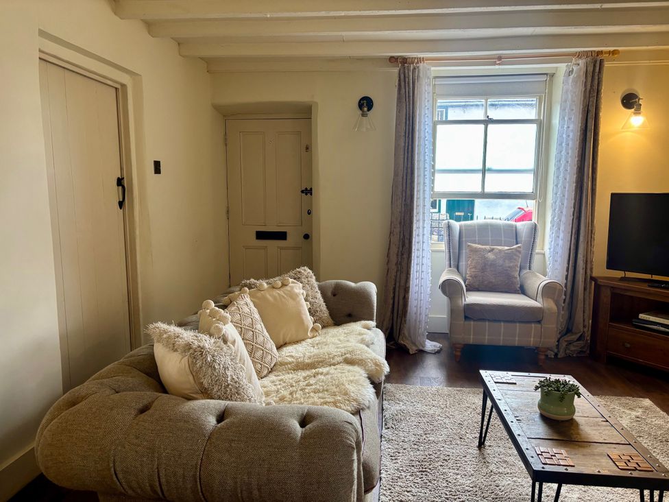 A living room with a sofa and armchair at Coupling Cottage in Belper