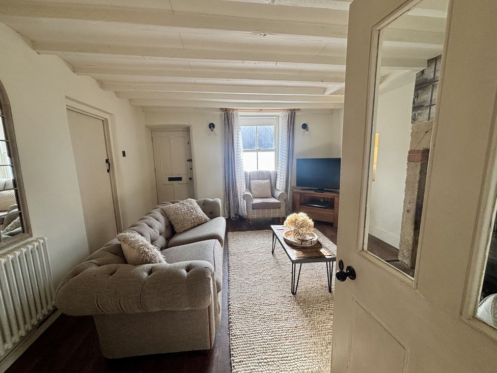 A living room with a sofa and armchair at Coupling Cottage in Belper