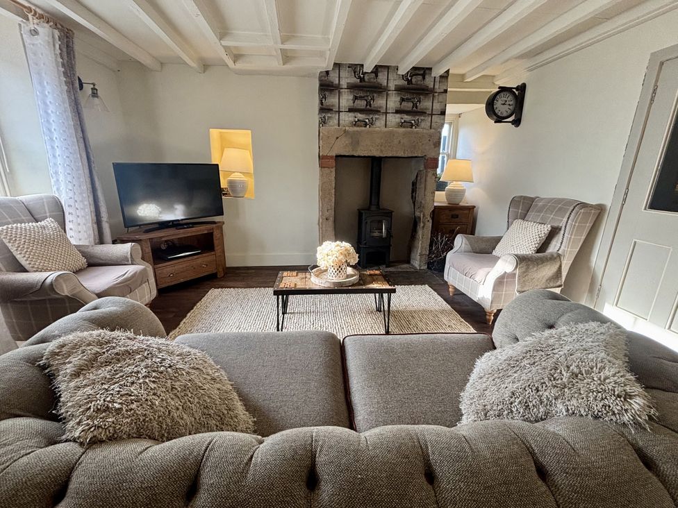 A living room with a sofa and armchairs at Coupling Cottage Belper