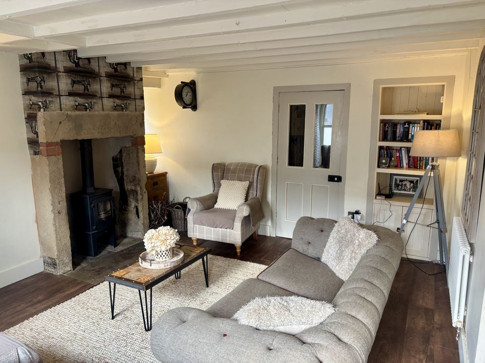 A living room with a sofa and armchair at Coupling Cottage in Belper