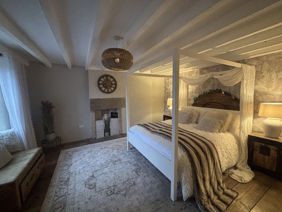 A bedroom with a bed and bedside tables at Coupling Cottage in Belper