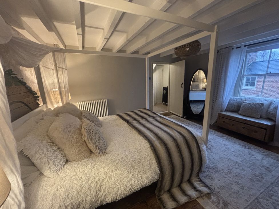 A bedroom with a bed and seating area at Coupling Cottage in Belper