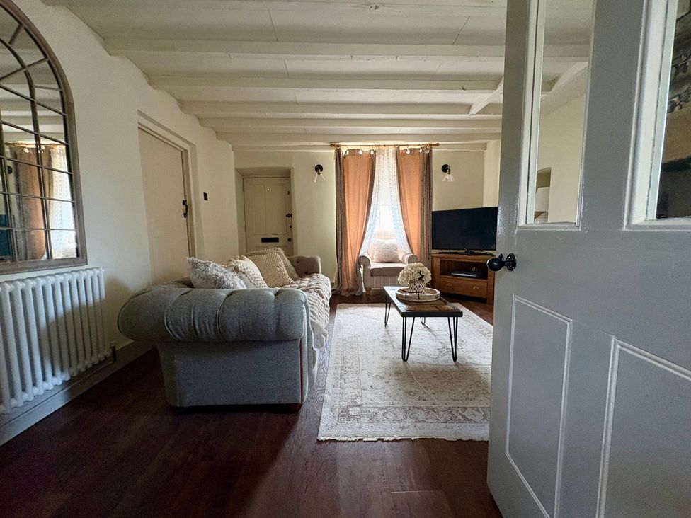 A living room with a sofa and coffee table at Coupling Cottage in Belper
