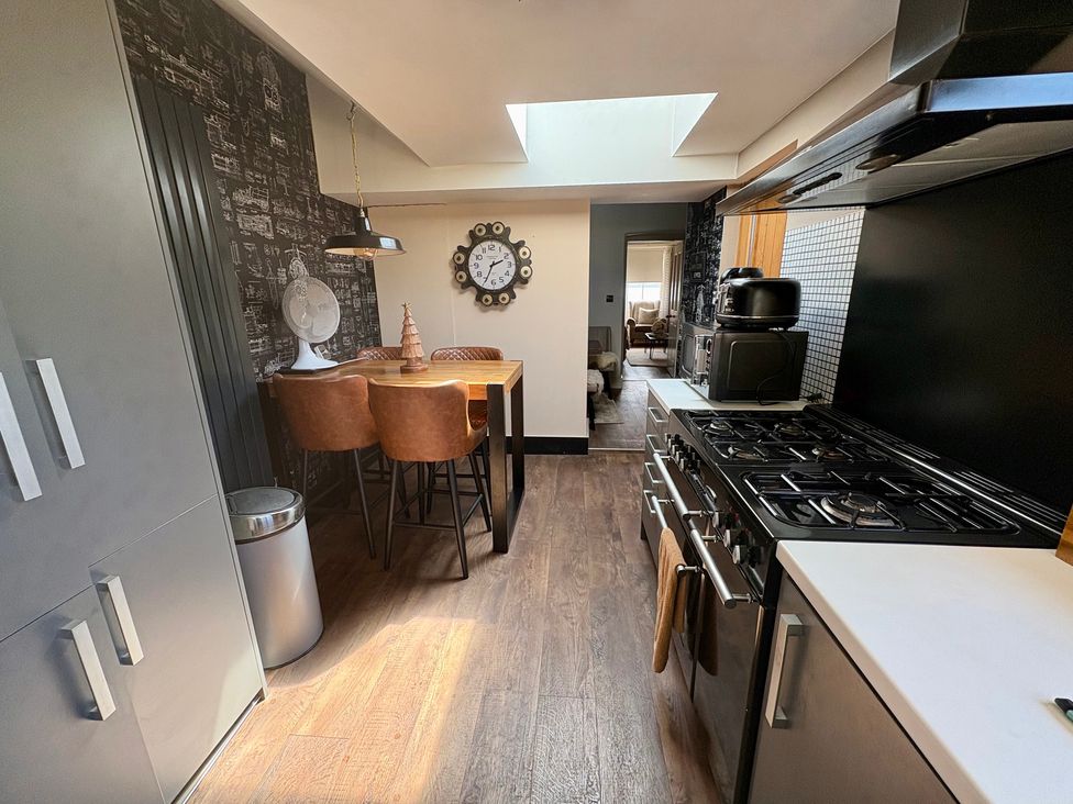 A kitchen with a table and chairs at Coupling Cottage in Belper