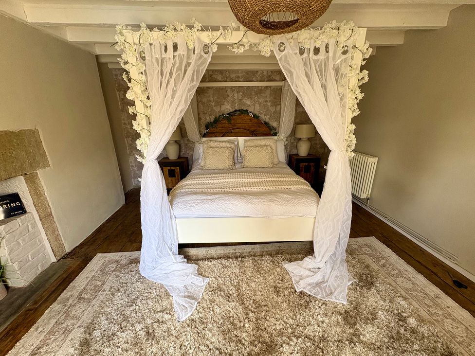 A bedroom with a bed and bedside tables at Coupling Cottage in Belper