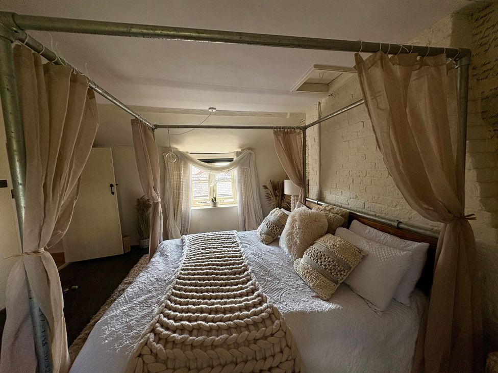 A bedroom with a bed and window at Coupling Cottage in Belper