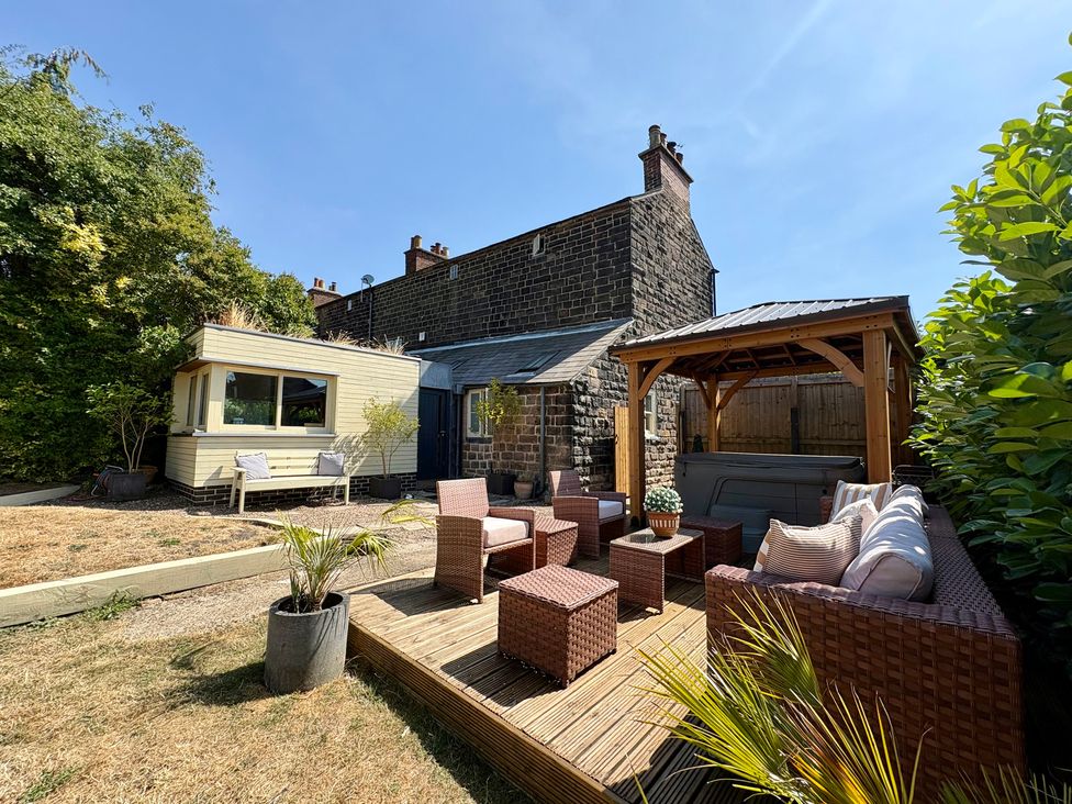 A garden with seating and a hot tub at Coupling Cottage Belper