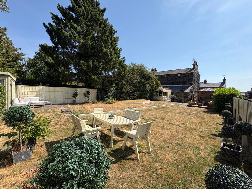 A garden with seating area and shed at Coupling Cottage in Belper