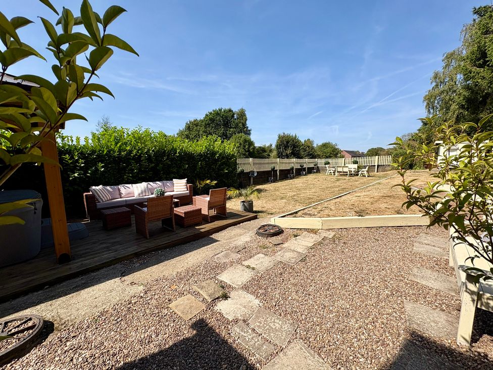 A garden with a seating area and table at Coupling Cottage in Belper