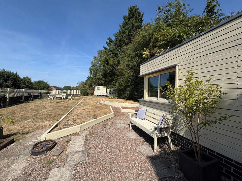 A garden with gravel path and outdoor seating at Coupling Cottage in Belper