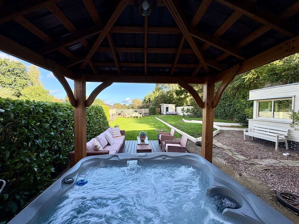 A garden with a hot tub and outdoor seating at Coupling Cottage in Belper