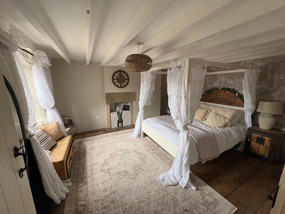A bedroom with a bed and bedside table at Coupling Cottage in Belper