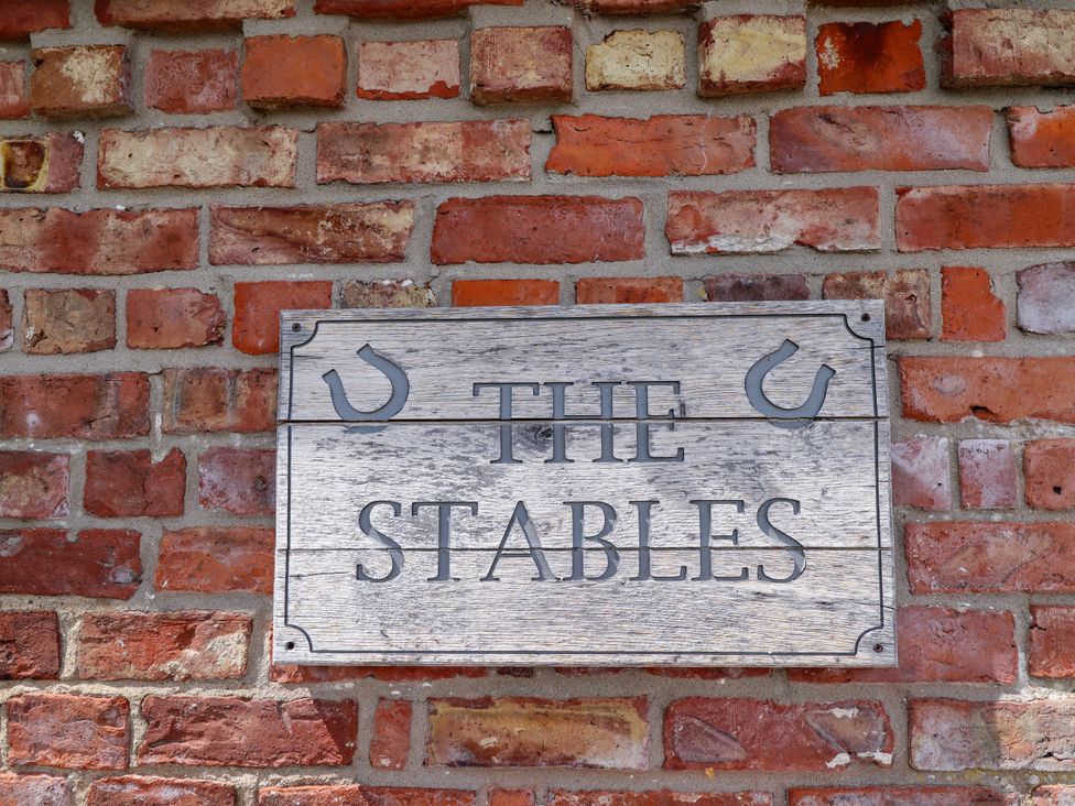 A sign that reads The Stables on a brick wall at The Stables Wrangle near Old Leake