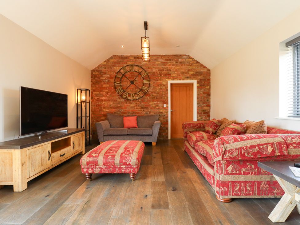 A living room with a sofa and television at The Stables in Wrangle near Old Leake