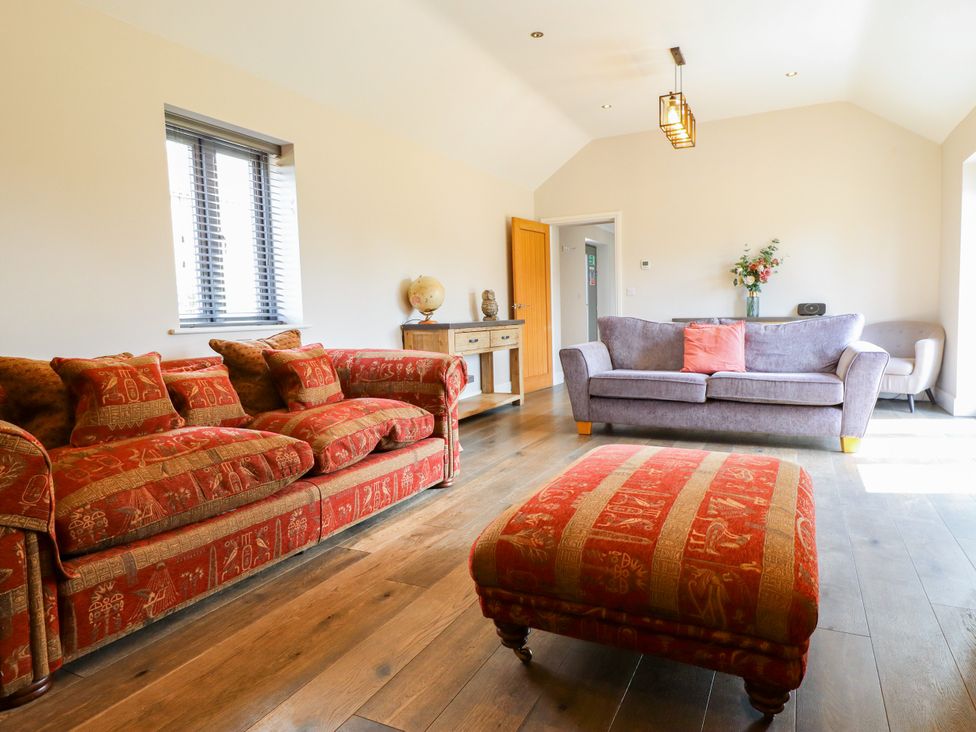 A living room with sofas and a table at The Stables in Wrangle near Old Leake