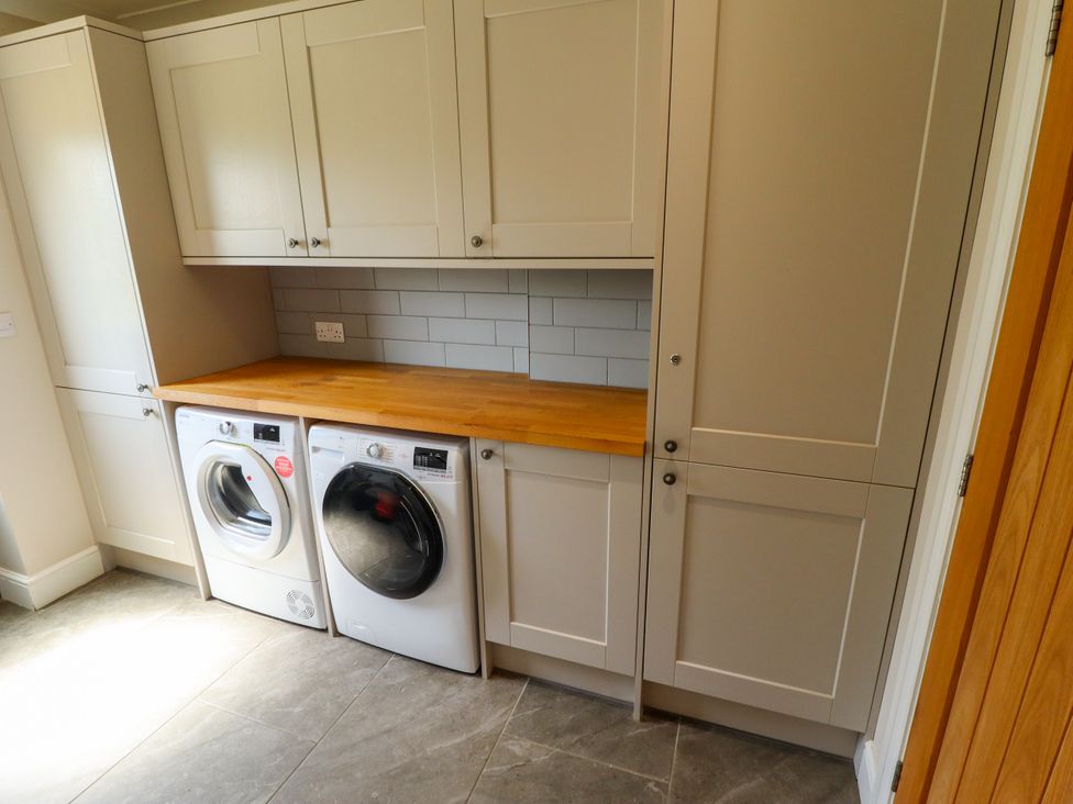 A laundry room featuring a washing machine and tumble dryer at The Stables in Wrangle near Old Leake