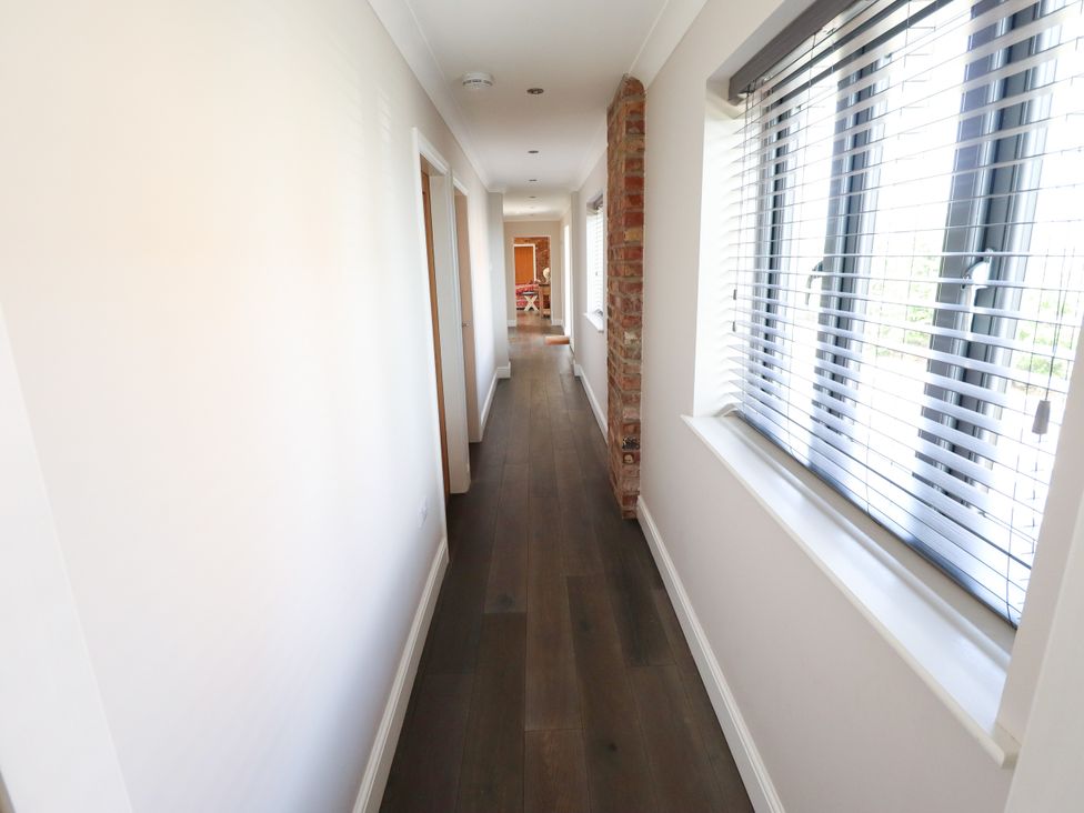 A hallway with a brick wall and windows at The Stables in Wrangle near Old Leake