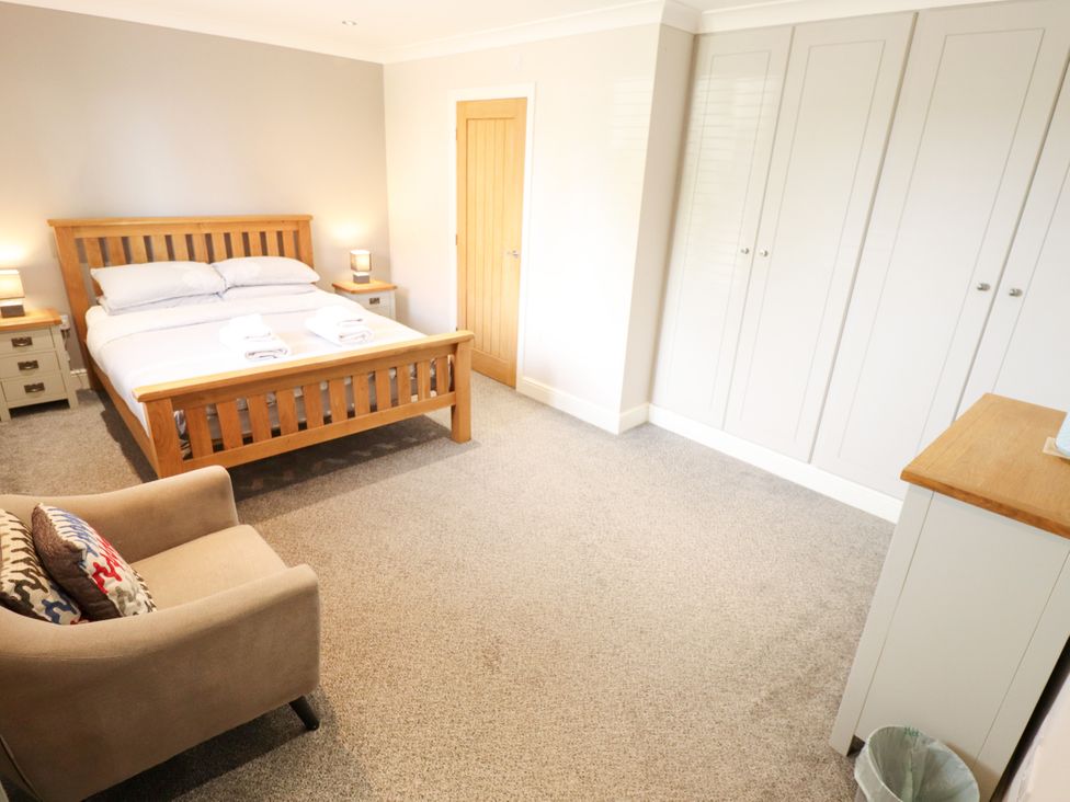 A bedroom with a bed and wardrobe at The Stables in Wrangle near Old Leake