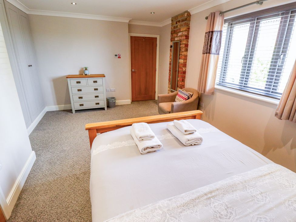 A bedroom with a bed and towels on it at The Stables in Wrangle near Old Leake