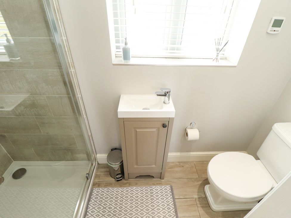 A bathroom featuring a shower, sink, and toilet at The Stables in Wrangle near Old Leake