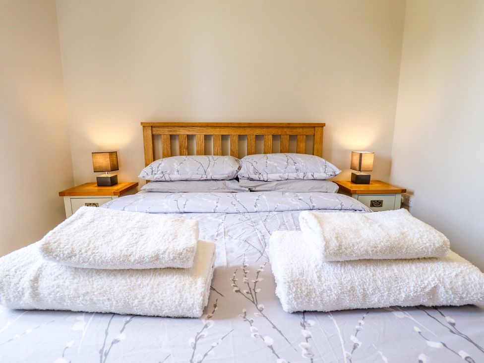 A bedroom with a bed and bedside tables at The Stables in Wrangle near Old Leake