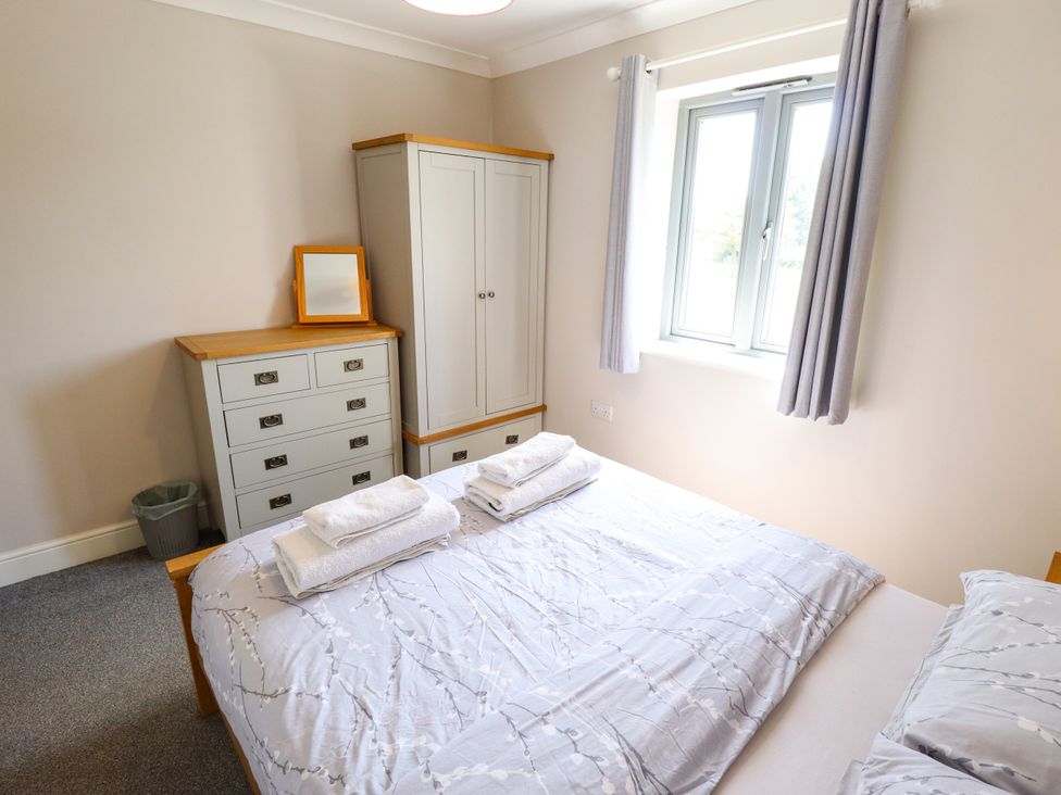 A bedroom with a bed and furniture at The Stables in Wrangle near Old Leake