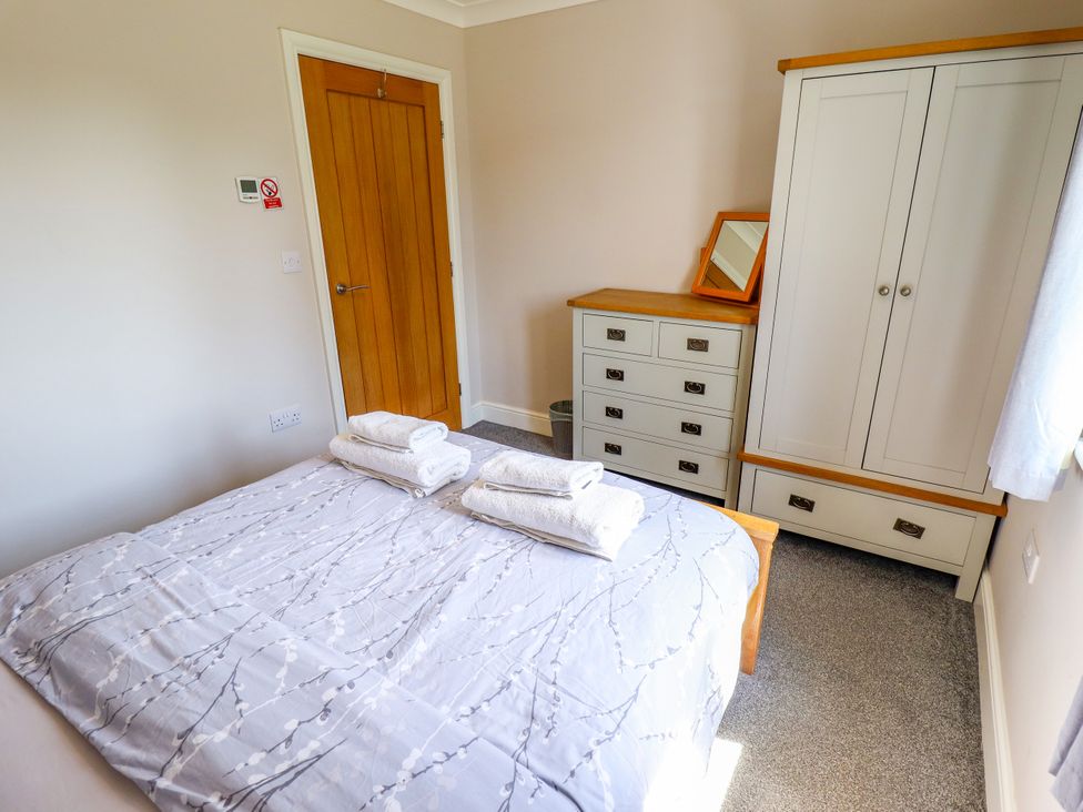A bedroom with a bed and wardrobe at The Stables in Wrangle near Old Leake