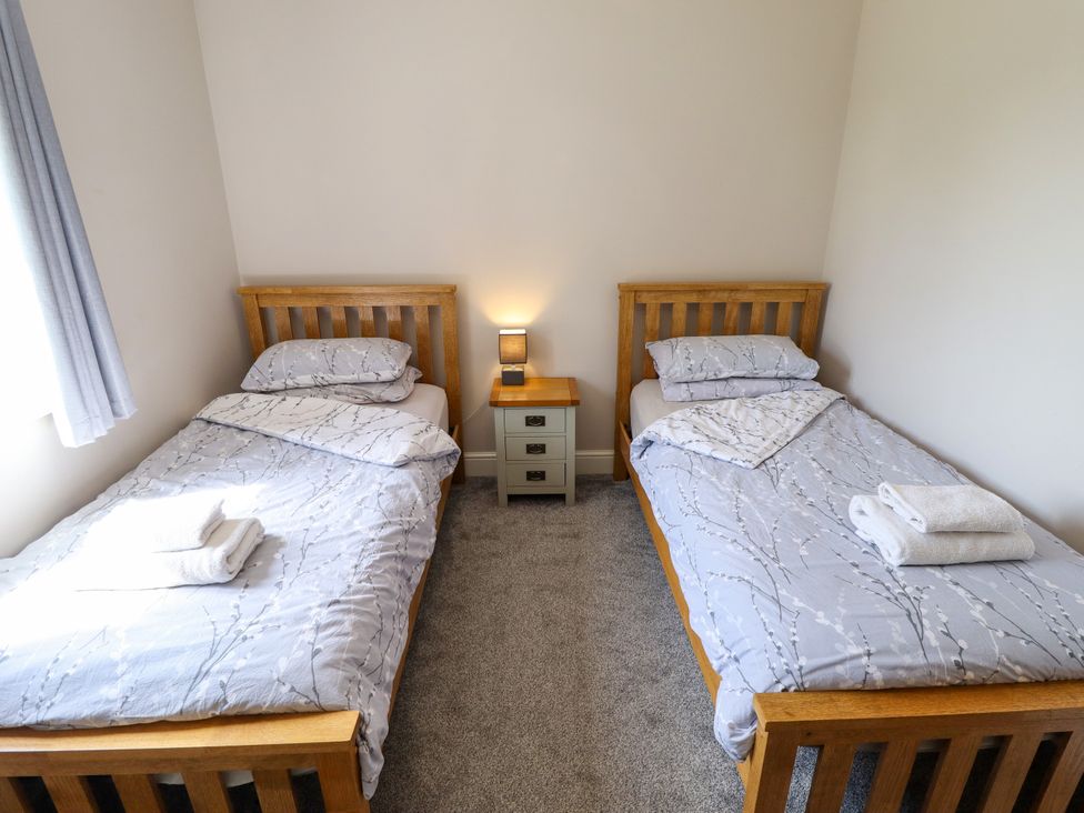 A bedroom with two single beds and a nightstand at The Stables in Wrangle near Old Leake