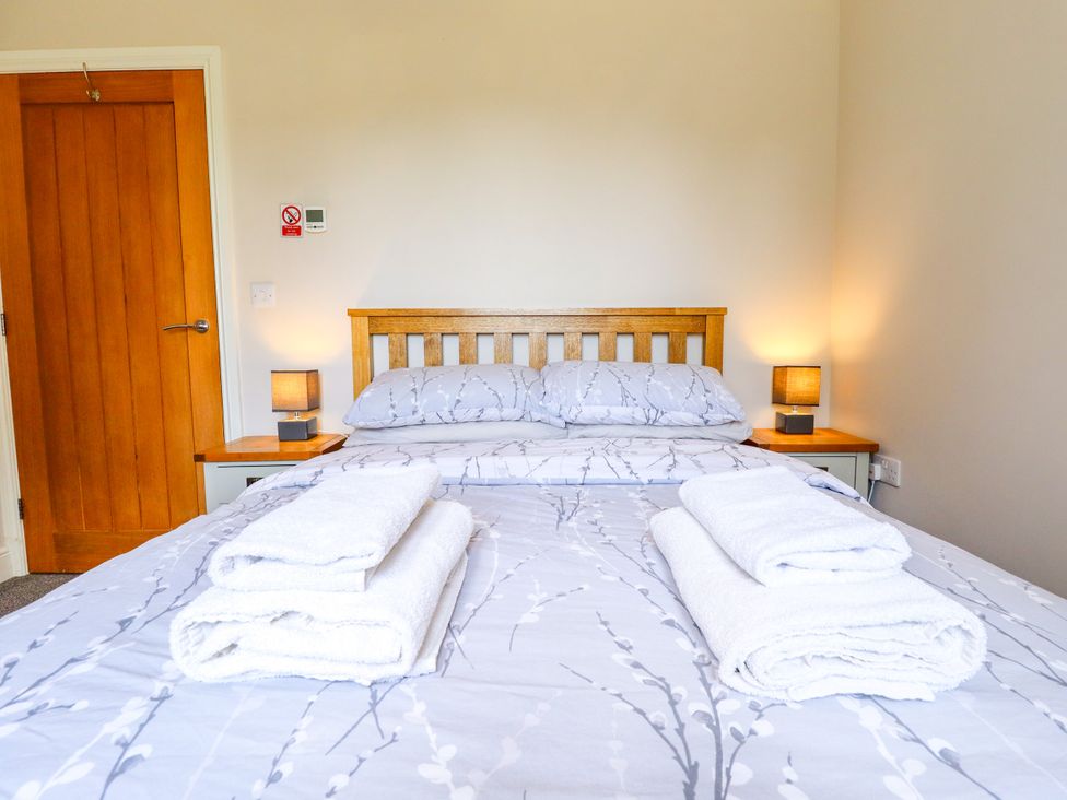 A bedroom with a bed and towels at The Stables in Wrangle near Old Leake