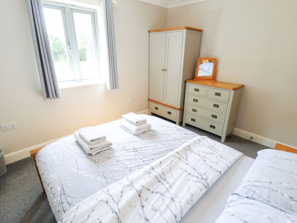 A bedroom with a bed and wardrobe at The Stables in Wrangle near Old Leake