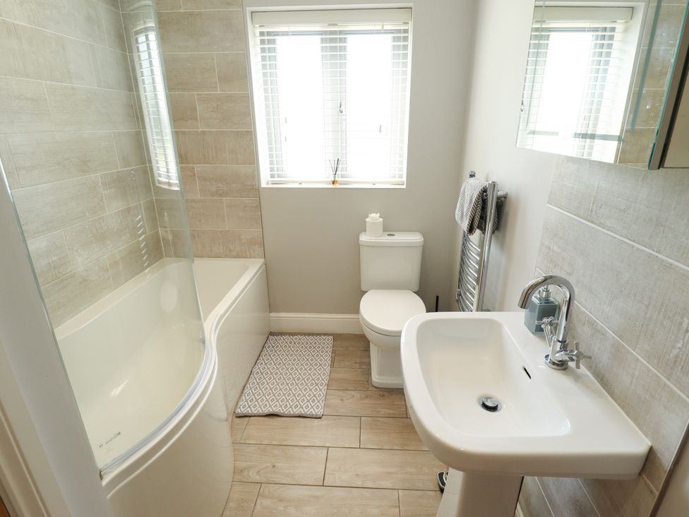 A bathroom with a bathtub and sink at The Stables in Wrangle near Old Leake