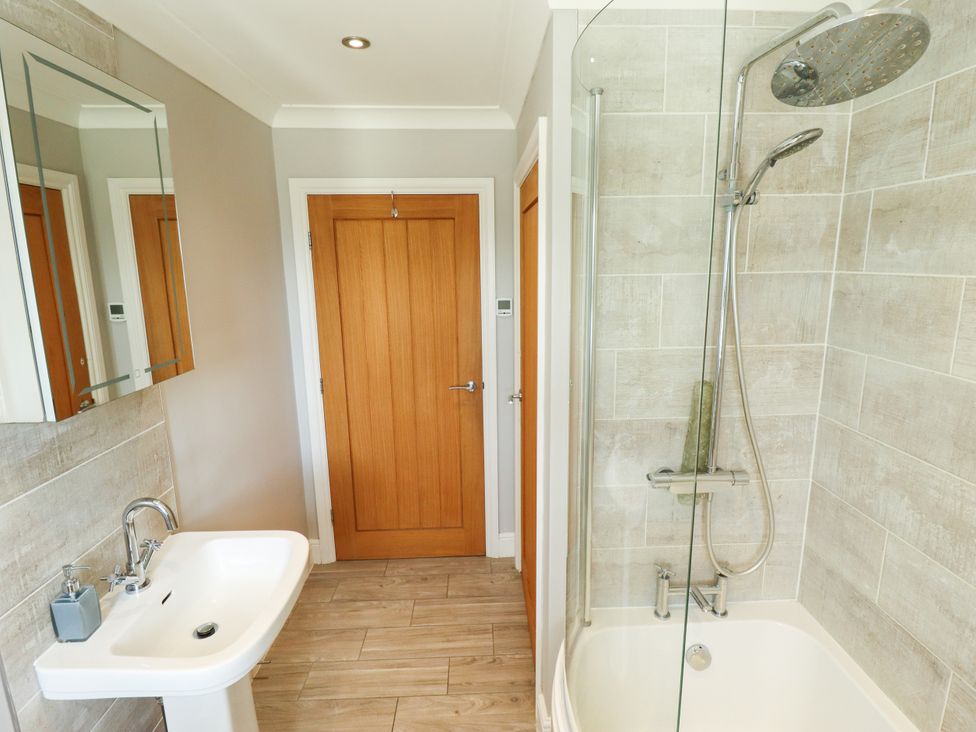 A bathroom with a shower and bathtub at The Stables in Wrangle near Old Leake